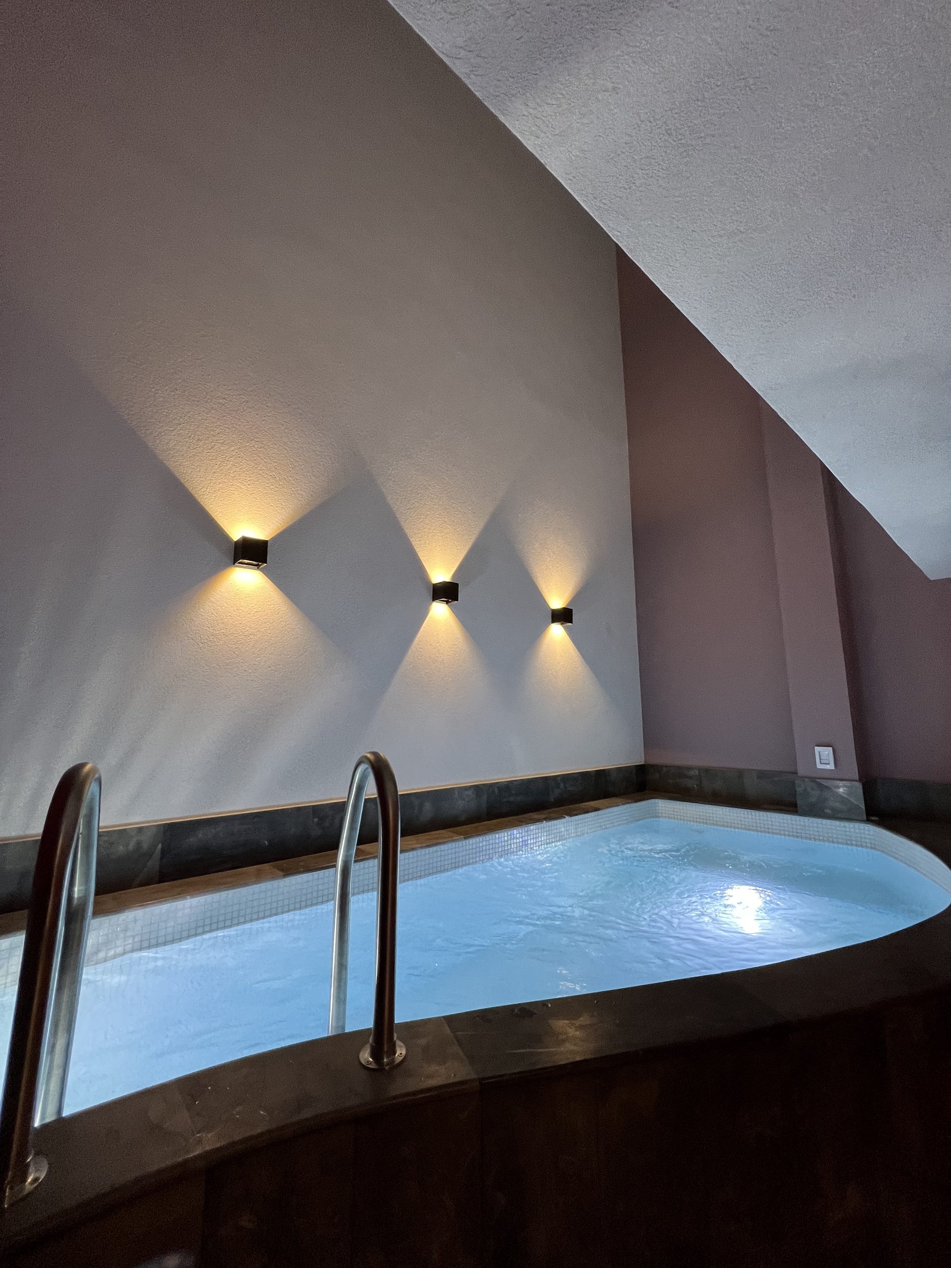 Alberca iluminada de la habitación con dos camas